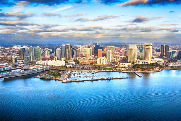 San Diego Skyline The skyline of downtown San Diego, California shot from an orbiting helicopter of San Diego Bay. marina california stock pictures, royalty-free photos & images