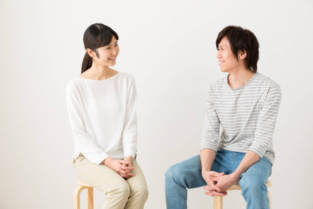 retrato de joven pareja asiática relajante - talking chair two people sitting fotografías e imágenes de stock