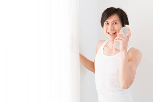 istock young asian man relaxing in living room 877912976