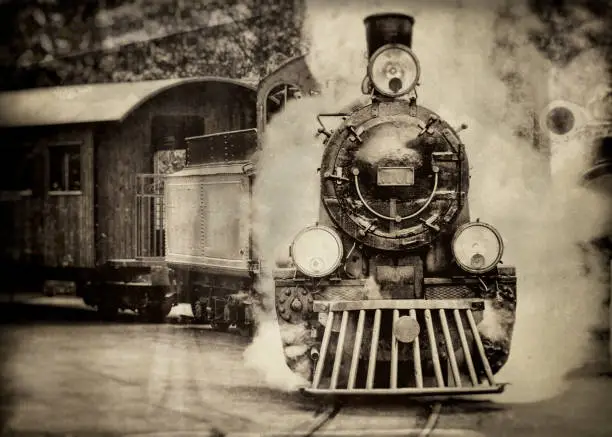 Steam train sorrounded by lots of smoke draws an passenger cabin, antique, sepia toned processed, wet plate and scratch processed,