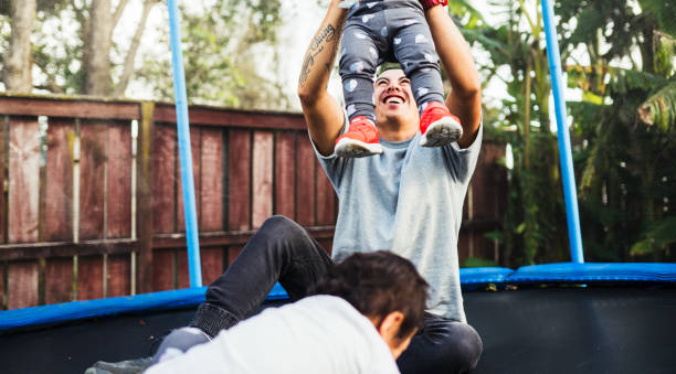 istock Father playing with kids on trampoline. 877949052