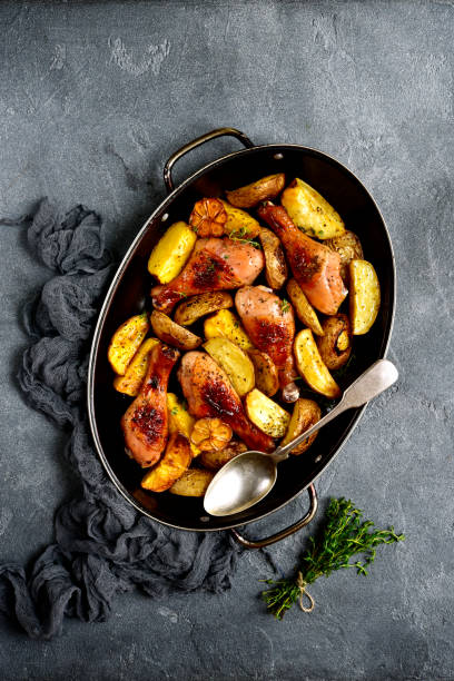 istock Chicken legs baked with potato in a skillet 877949210