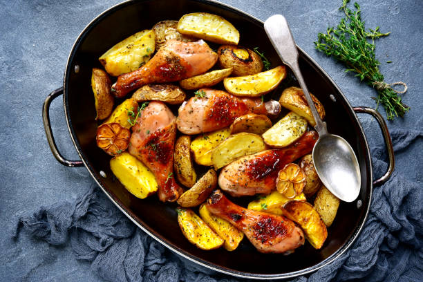 istock Chicken legs baked with potato in a skillet 877949242