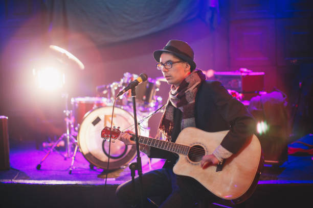 istock Young man singing and playing the guitar 877949376