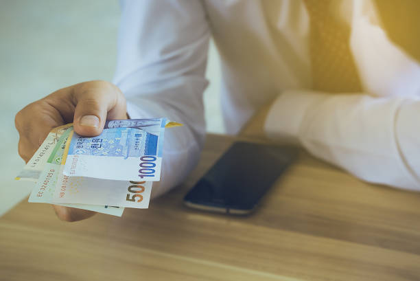 istock Midsection Of Man Holding Paper Currency At Table 877963002