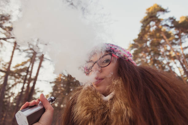 istock Electronic Cigarette. The girl smokes electronic cigarette. 877963256
