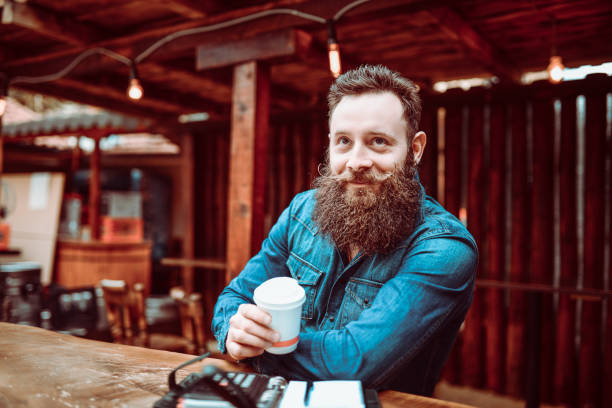 Bearded Handsome Hipster Man Drinking Coffee in a Cafe