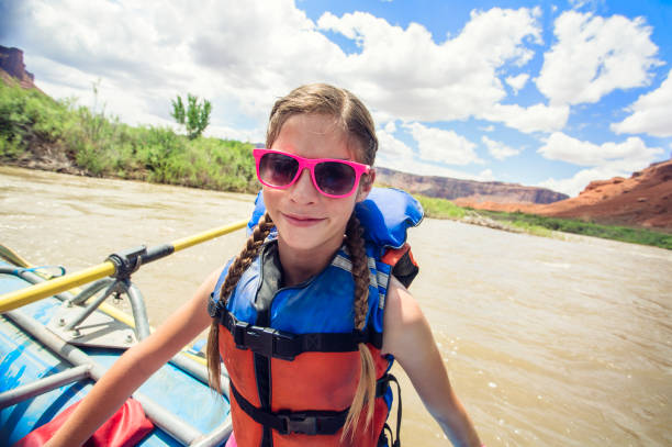 Smiling woman ready to board a large inflatable raft as she travels down the scenic Colorado River near Moab, Utah and Arches National Park