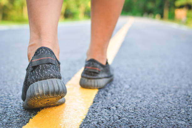 istock Low Section Of Man Walking On Road 878016040