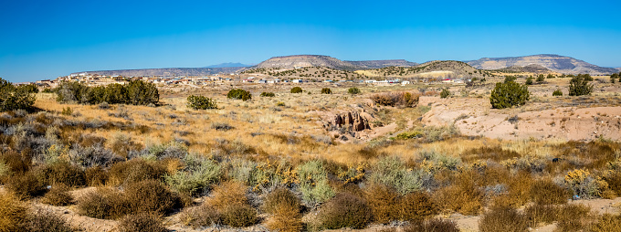A High Resolution Panaramic View of a Small New Mexico Village in the Desert Near Multi-colored Hills.