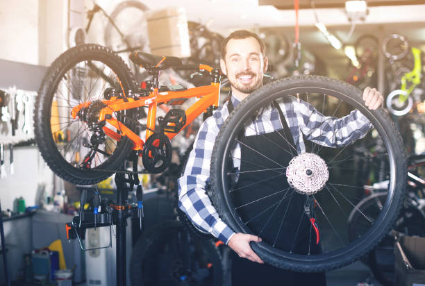 istock man in apron considering composition of wheel for bicycle 878016726