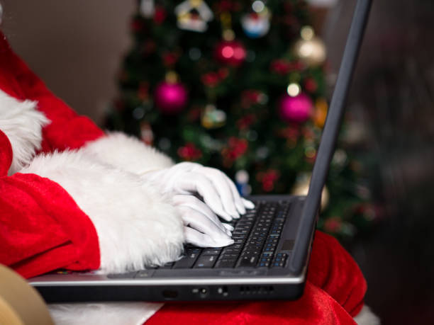 istock Midsection Of Santa Claus Using Laptop During Christmas 878019792
