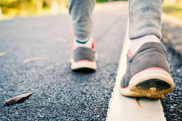 istock Low Section Of Person Walking On Road 878022606