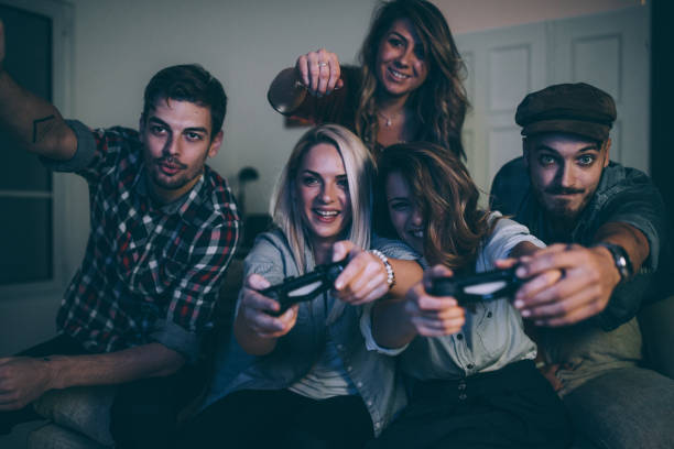 istock Happy young friends playing video games 878031282