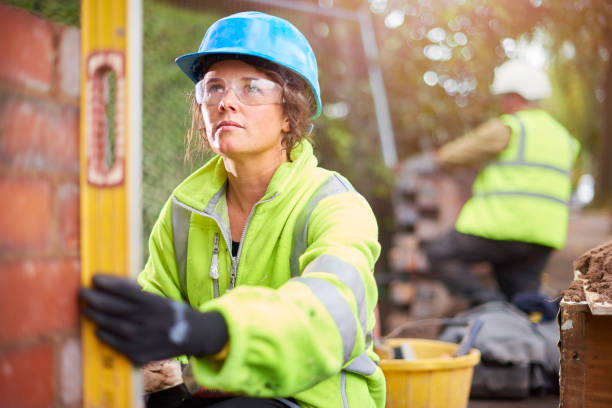 istock female brickie checking her levels 878037508
