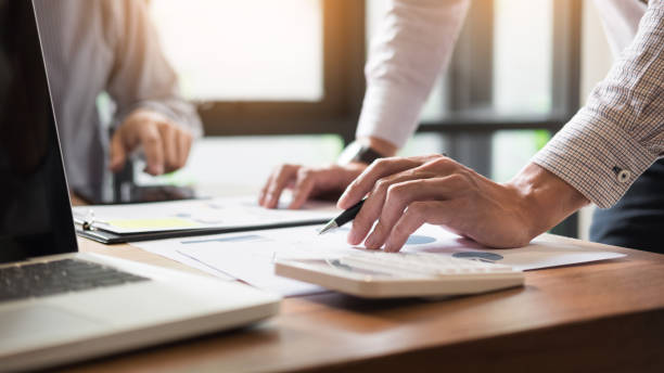 istock Cropped Hands Of Businessmen Working On Table At Office 878053090