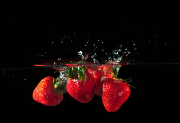 istock Strawberries splashing into water 878062570