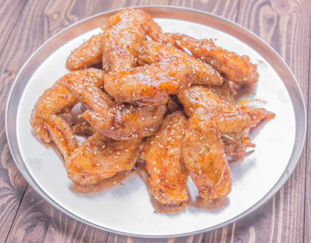 plate tray of fried chicken wings on brown wooden table