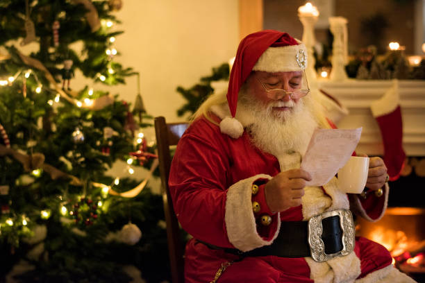 istock Santa claus reading a Christmas wishlist 878070282