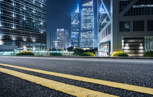 istock empty highway against modern illuminated skyscrapers of Hong Kong 878084574