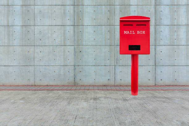 roten briefkasten auf zementboden mit weißzement blockwand - mailbox mail box side view stock-fotos und bilder