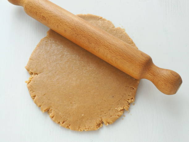 istock Rolling dough for gingerbread, cookies, shortbread, cakes, pastries, or pizza with rolling pin. 878115992