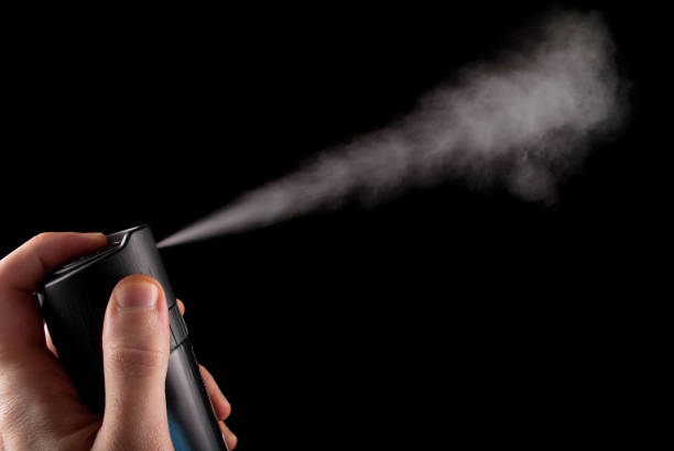 istock Deodorant spray in hand and white aerosol isolated on black background 878119366