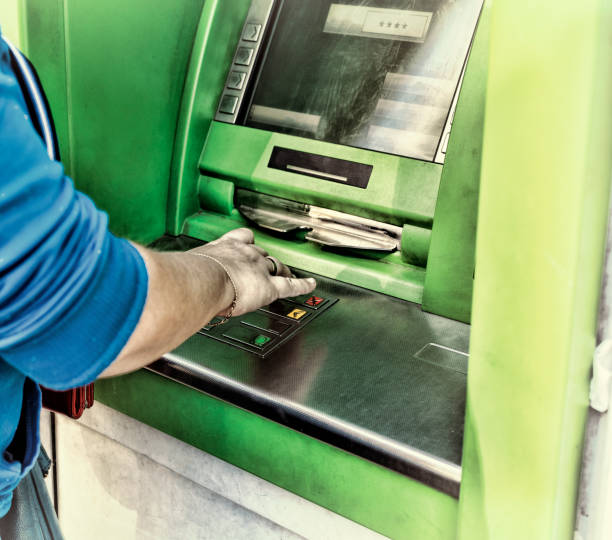 istock Young woman using a cash point. Young girl using ATM 878121572