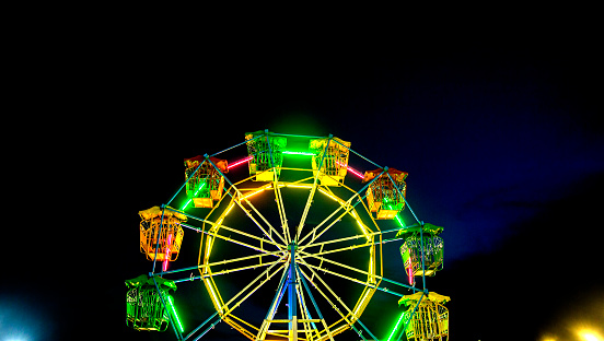 close up ferris wheel with neon light at night carnival park