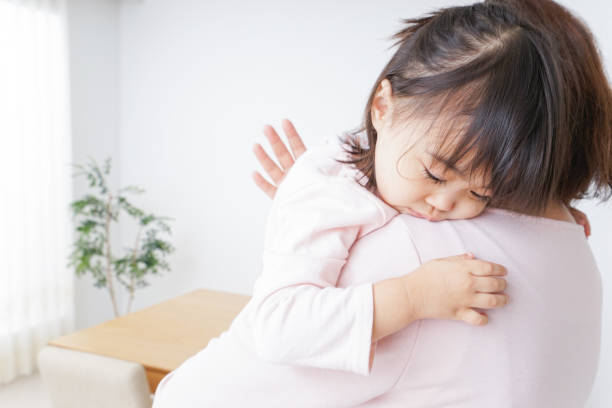 istock Sleeping child carried by mother 878124652