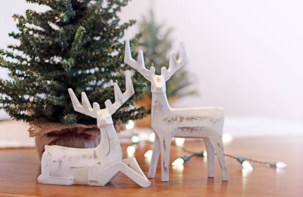 Deer Christmas decorations with lights and trees on table