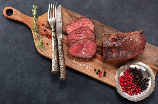 istock Roast beef with rosemary top view 878137836