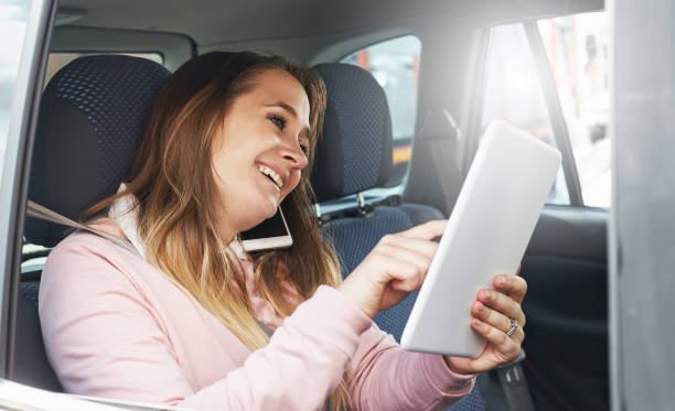 passeggero dell'auto sorridente impegnato con il suo tablet digitale - head rest foto e immagini stock