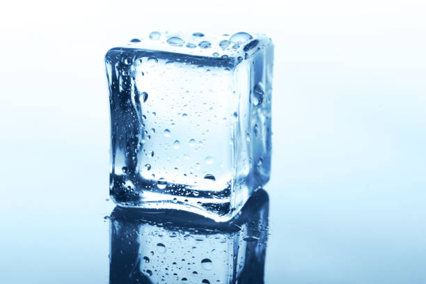istock Transparent ice cube with reflection on blue glass with water drops 878164254
