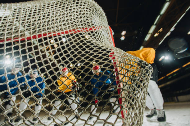 close up of ice hockey goalkeeper's net with hockey puck in it. - ice hockey hockey puck playing shooting at goal imagens e fotografias de stock