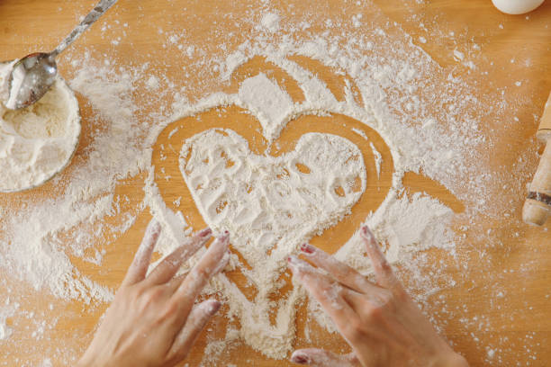 istock Hand drawn heart in flour on the kitchen table and other ingredients. Top view. 878164852