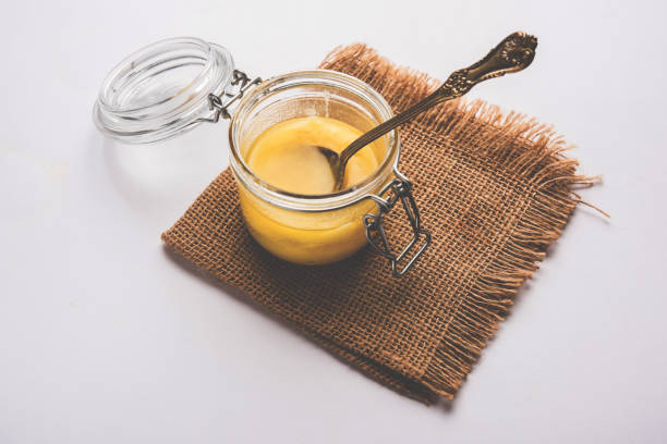 istock Desi Pure Ghee or clarified butter in glass or Copper container with spoon, selective focus 878170220