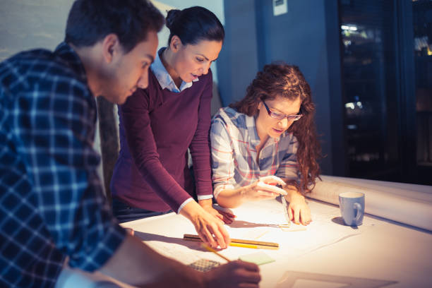 istock Working Late. Group of young architects working late in office 878176050