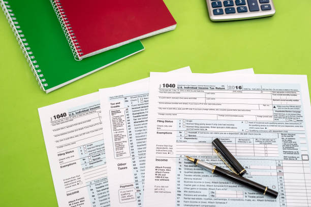 istock 1040 Tax form, pen and calculator 878177562