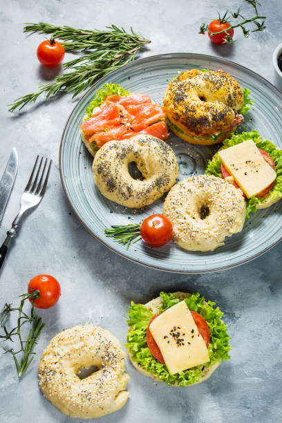 istock Bagels with salmon, vegetables, cream-cheese on grey concrete background 878184724