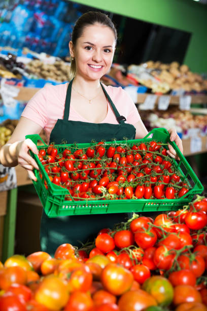 istock Saleswoman with box of tomatoes 878185100
