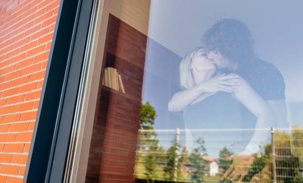 istock Couple kissing behind the window 878194934
