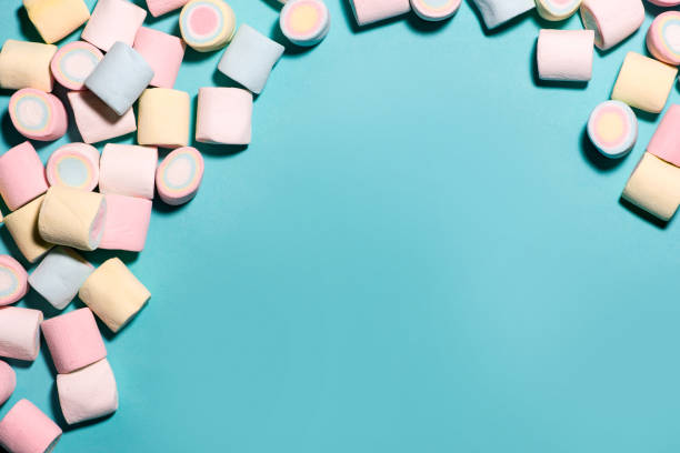 istock Top view of pastel colored marshmallow on a blue background. Minimalism style. 878204772