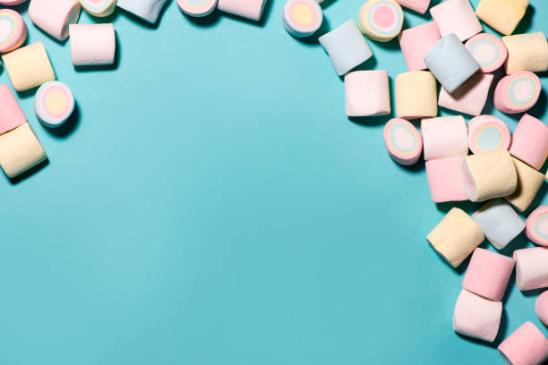 istock Top view of pastel colored marshmallow on a blue background. Minimalism style. 878204814