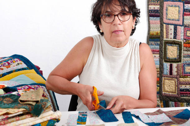 istock a mature brunette woman cutting fabric for sewing patchwork 878205374