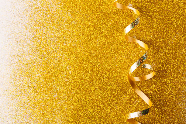 istock Curly golden serpentine on glitter background 878208960