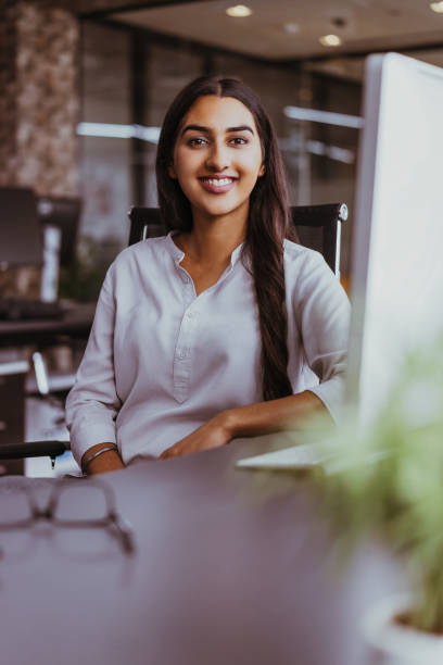 istock Portrait of cheerful female leader at computer 878210330