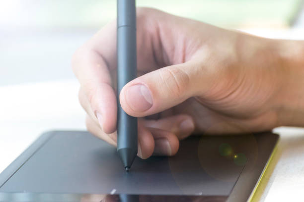 istock Hand of a young man writes on a graphics tablet 878214660