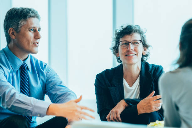 Three Business Colleagues Meeting in Lounge