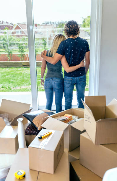 istock Embraced couple looking through the window 878222530